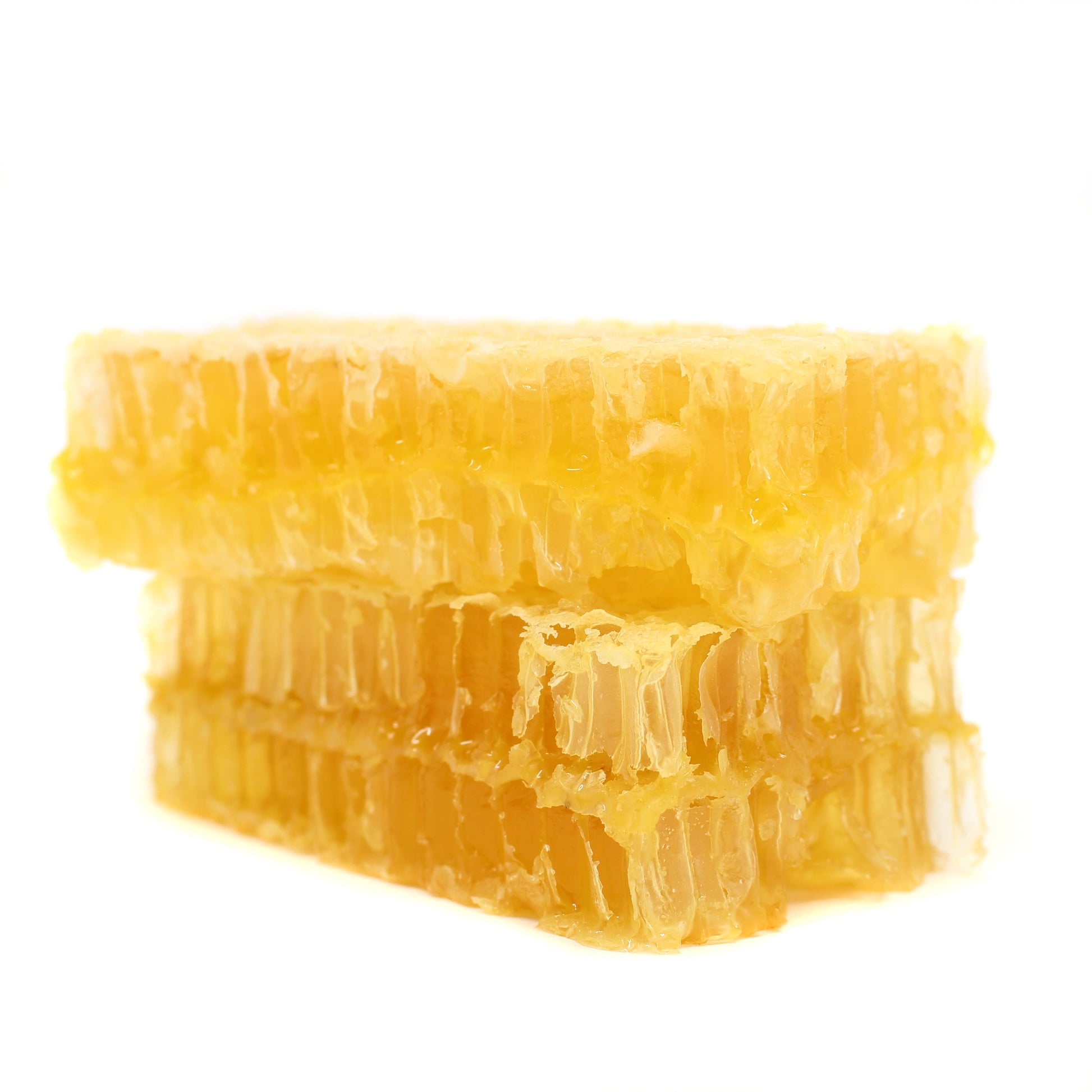 Stacked raw honeycomb from BannerBee Company LLC, showcasing golden honey-filled beeswax cells in a 6oz portion.