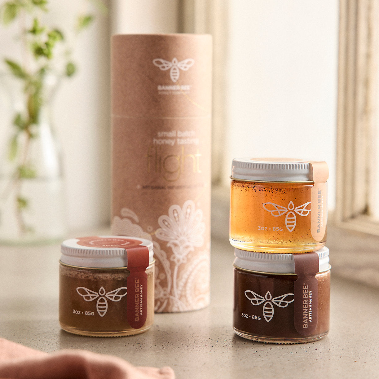 Assorted honey flight sample set from BannerBee Company LLC, featuring various flavors of honey in small jars.