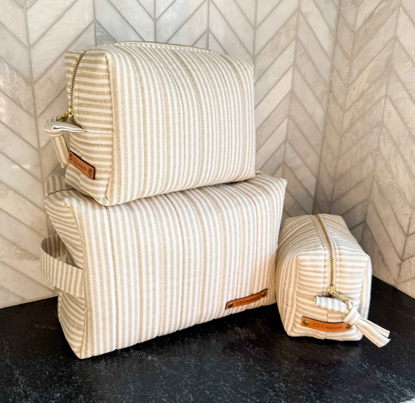 Handmade C2 Creations LLC makeup bag with taupe and cream ticking stripe pattern, boxy toiletry and makeup storage bag.