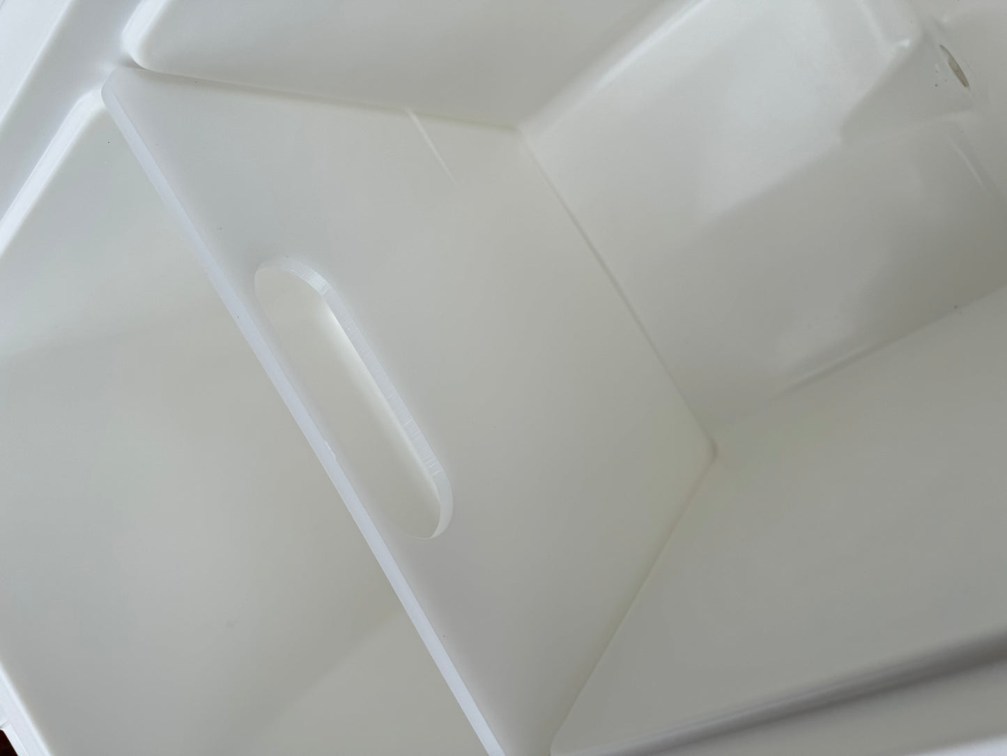 Polar Bear 20 Hard Cooler by Polar Bear Coolers, showing a rugged white cooler with a black lid and handle in a natural outdoor setting.