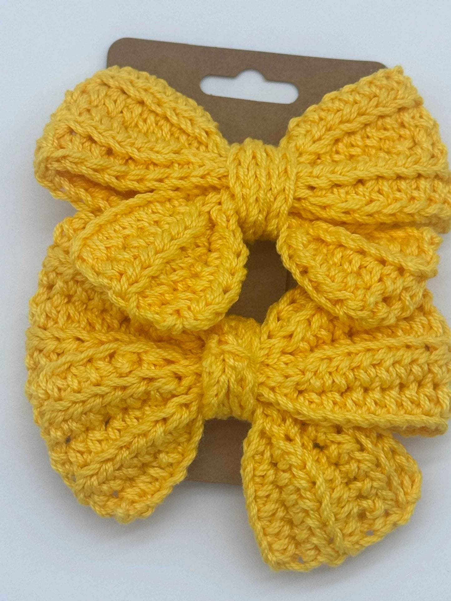 Handcrafted crochet bow hair accessory by C2 Creations LLC, featuring a colorful, textured bow for stylish hair decoration.