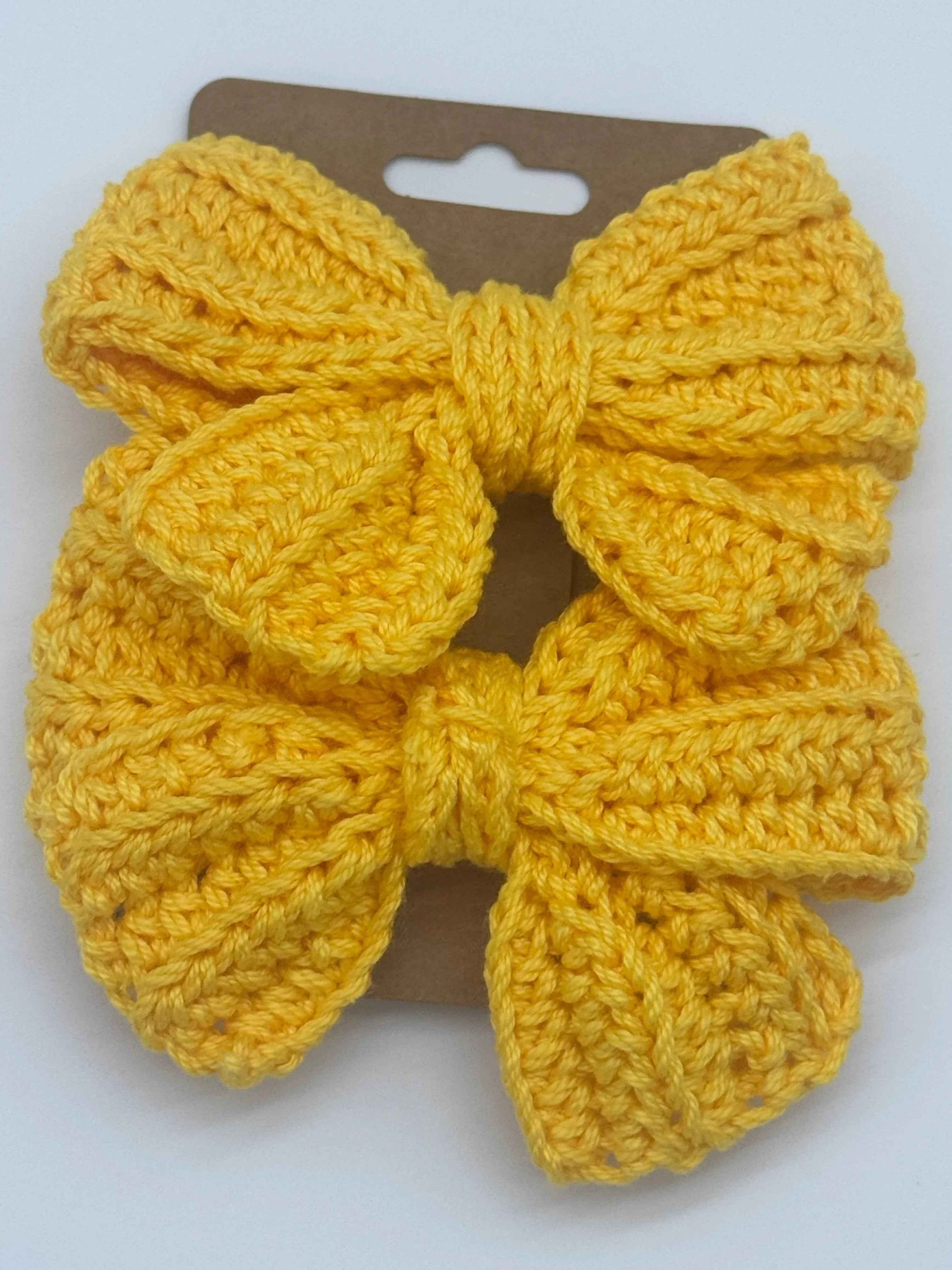 Handcrafted crochet bow hair accessory by C2 Creations LLC, featuring a colorful, textured handmade bow for stylish hair decor.