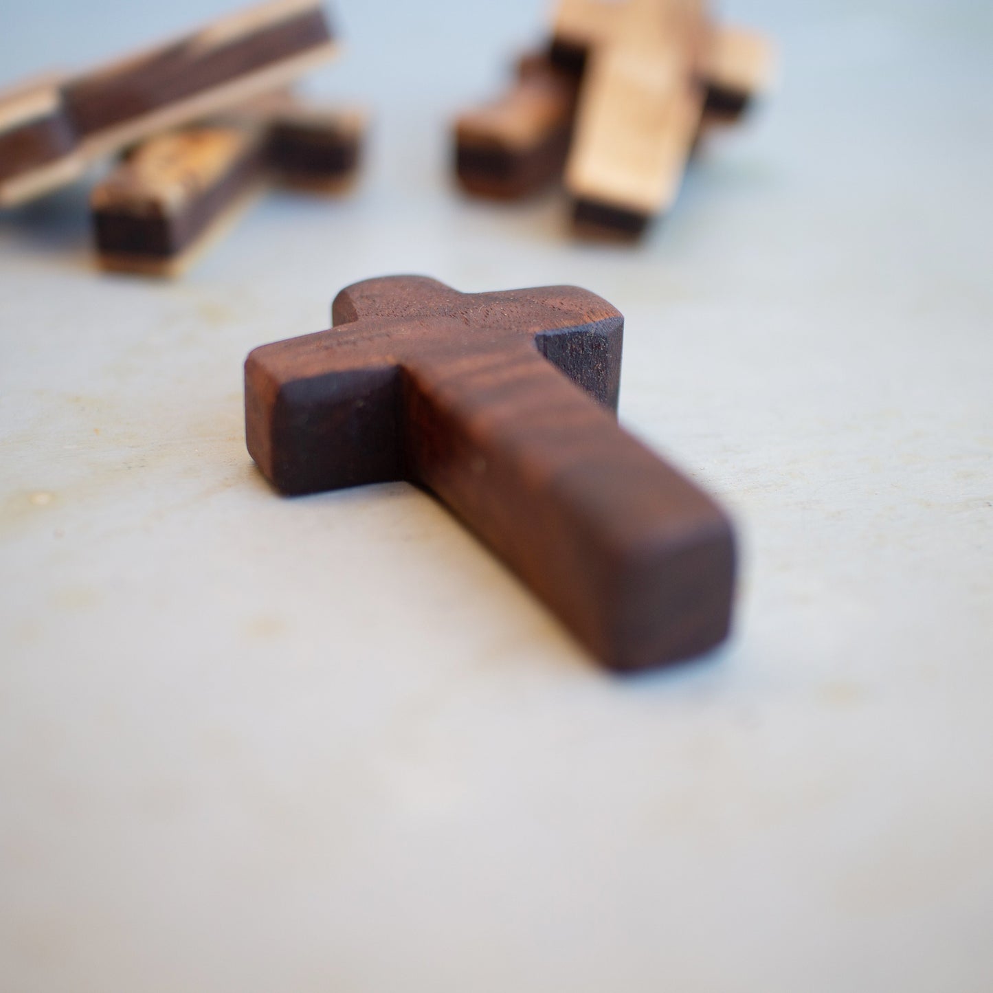 Handmade wooden pocket crosses by Dennehey Design Co., small wooden crosses suitable for personal or spiritual use.