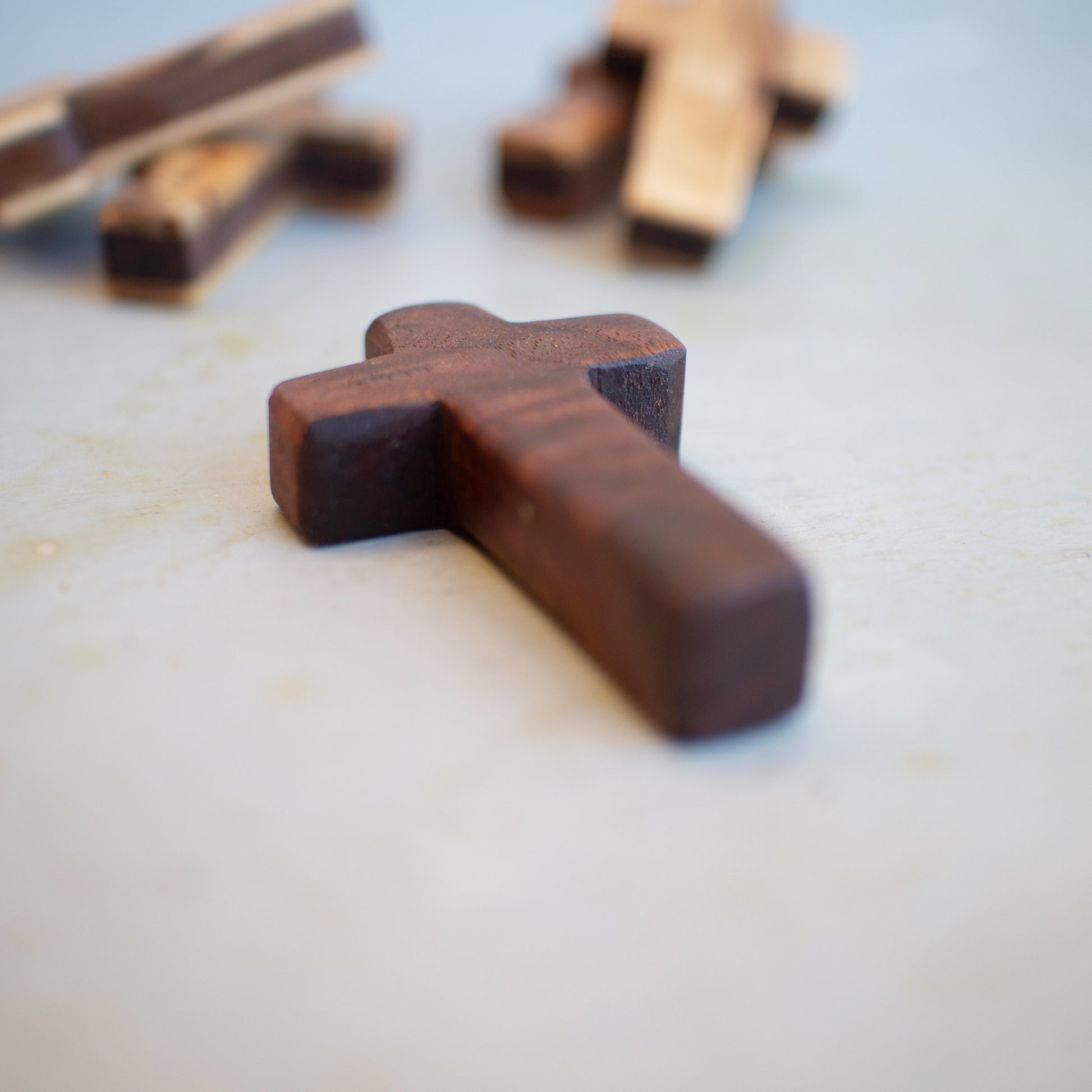 Handmade wooden pocket crosses by Dennehey Design Co., small wooden crosses suitable for personal or spiritual use.
