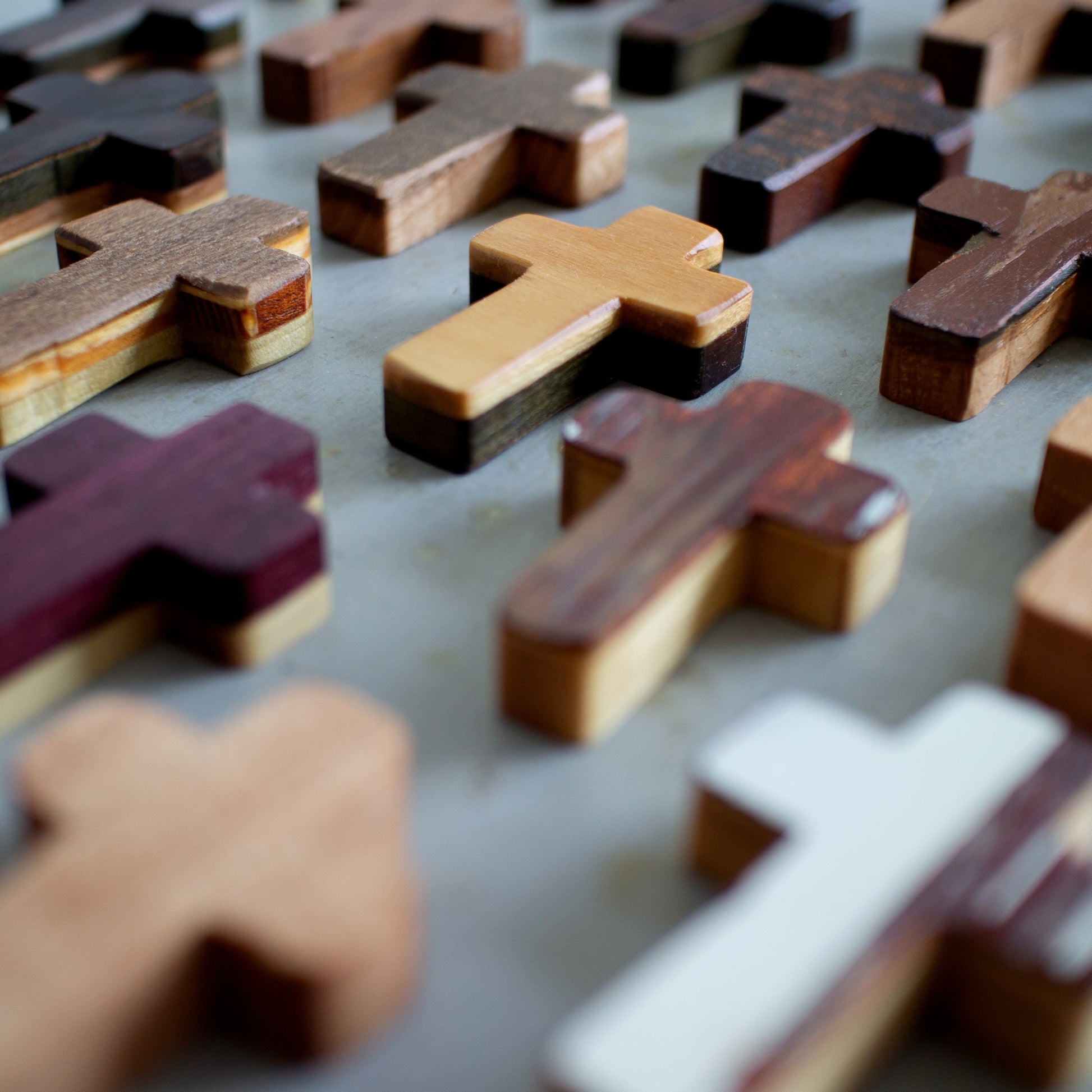 Handmade wooden pocket cross by Dennehey Design Co. featuring a natural wood finish and compact, portable design.