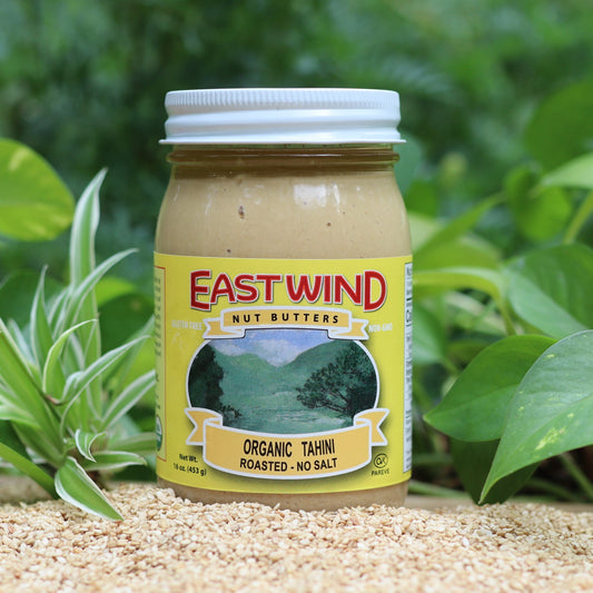 Organic tahini jar from East Wind Crafts showing smooth sesame paste in a glass container.