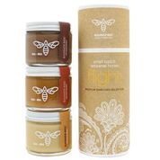 Assorted honey flight tasting set by BannerBee Company LLC, featuring different honey varieties in small jars with honey drizzles.