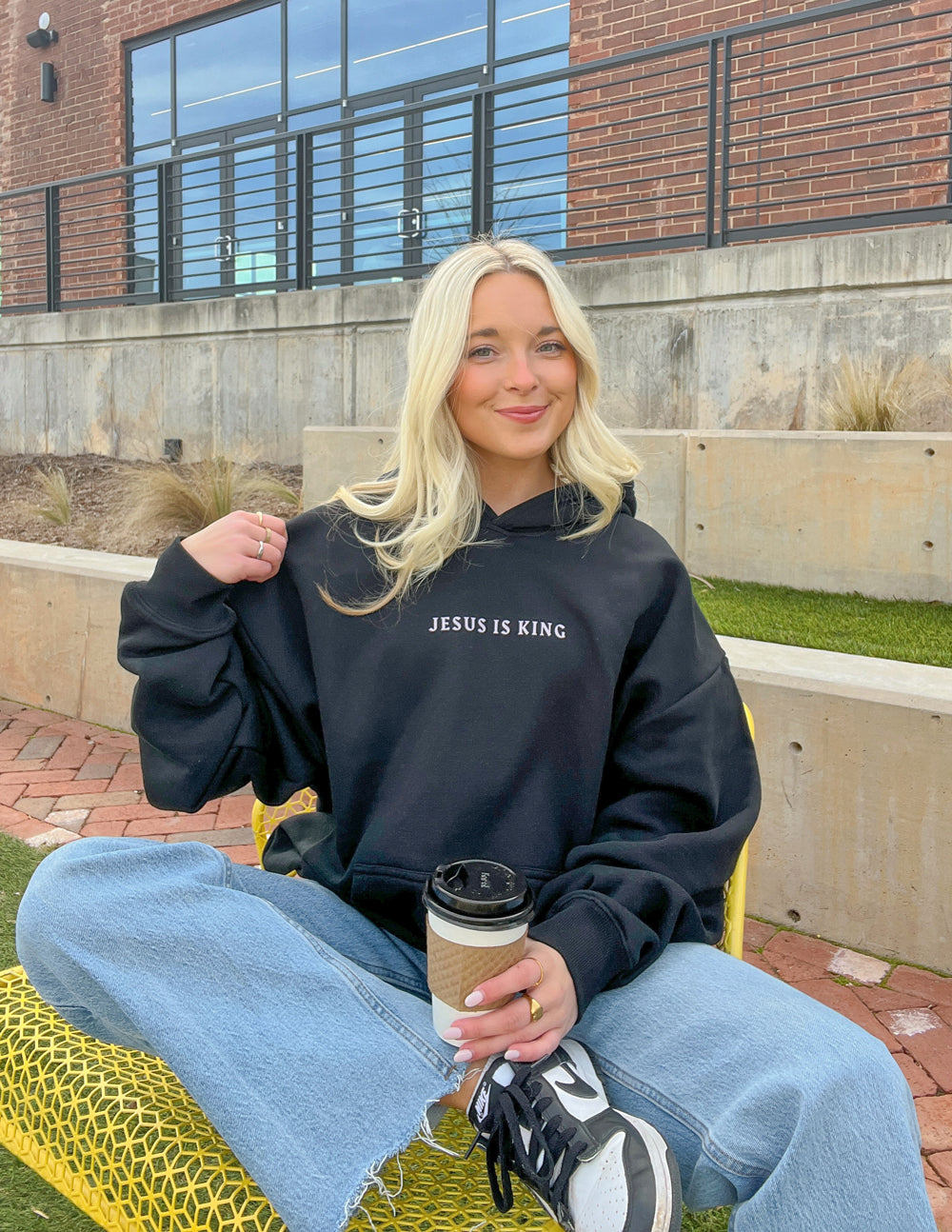 Black unisex hoodie featuring Jesus Is King design by Elevated Faith, casual wear with religious graphic print.