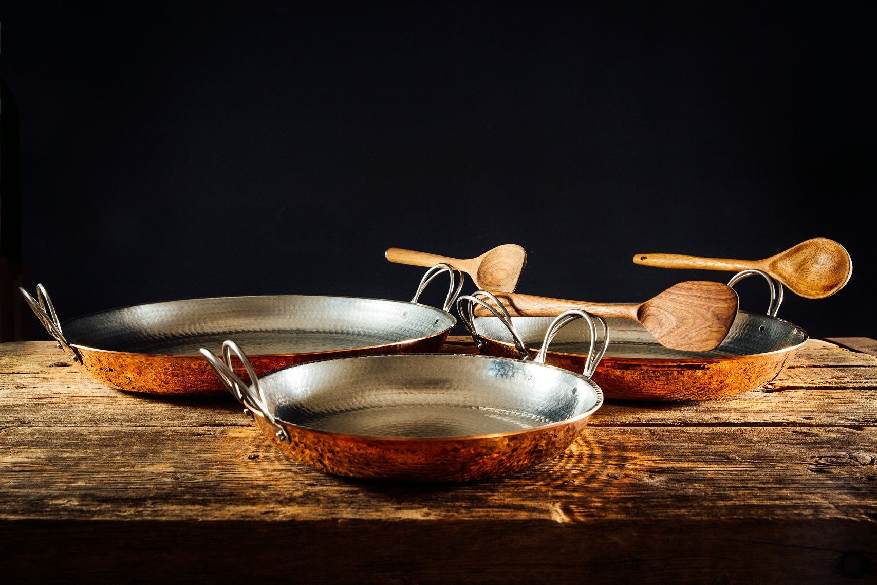 Alicante Copper Paella Pan by Sertodo with serving set and ladle, showcasing a large, round copper cookware with wooden handles.