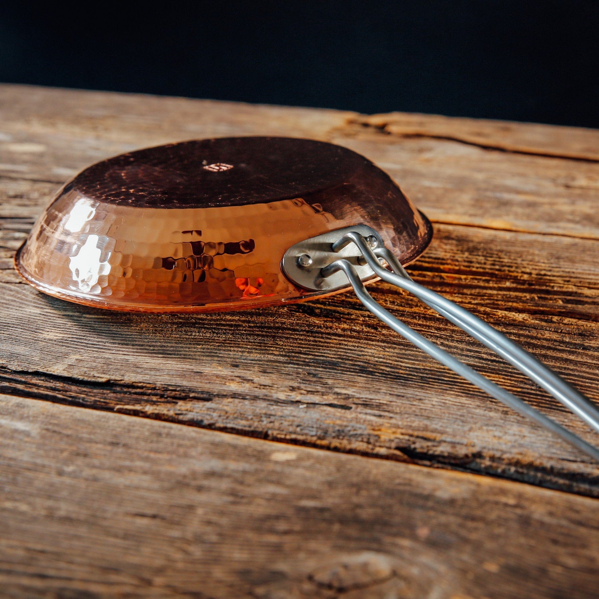 Close-up of a Sertodo copper skillet handle showing the detailed craftsmanship and polished copper surface.