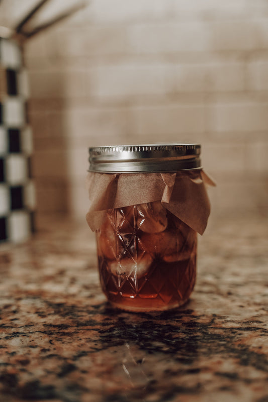 Old Fashioned Honey Garlic herbal remedy from Onic Brands LLC in a jar with honey, garlic cloves, and herbal ingredients visible.