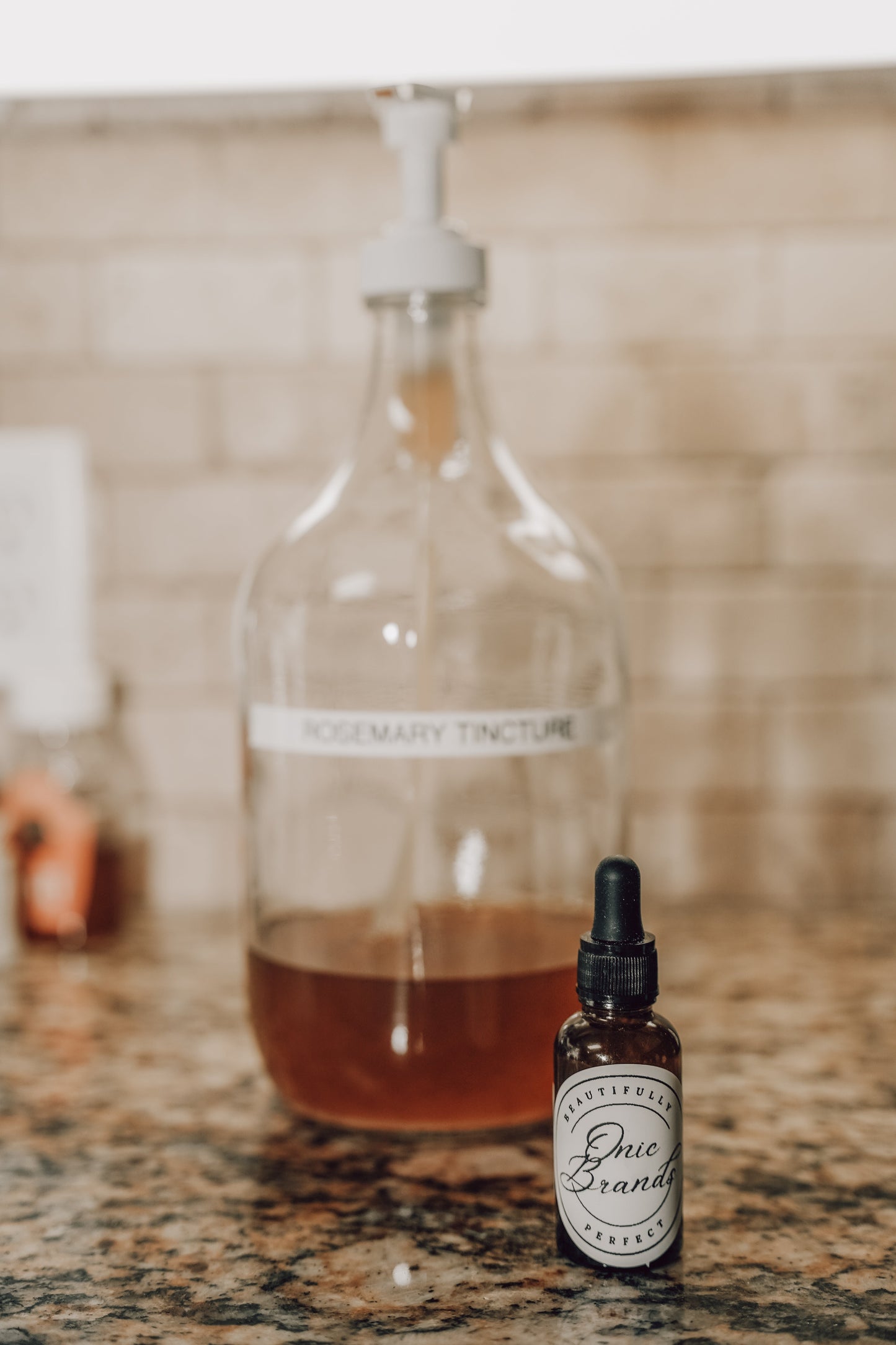 Onic Brands Elemental Rosemary Tincture bottle with dropper, herbal supplement in a glass container, on a neutral background.