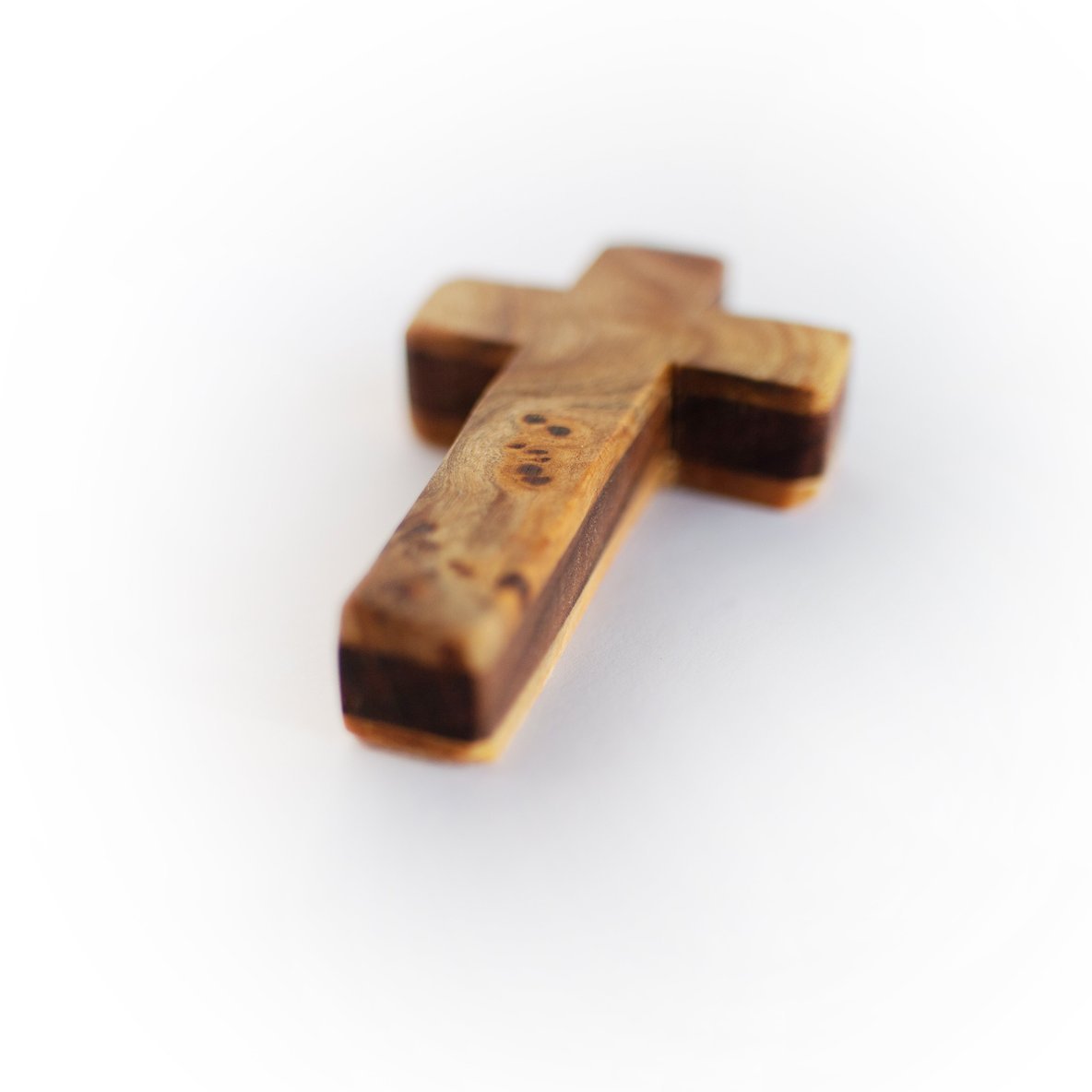 Handmade wooden pocket cross by Dennehey Design Co., small natural wood cross with detailed grain and smooth finish.