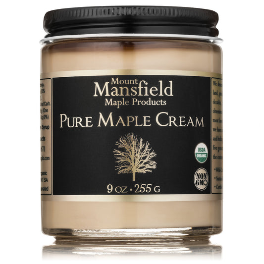 Creamy organic Vermont maple cream from Mount Mansfield Maple Products, shown in a jar on a rustic wooden surface.