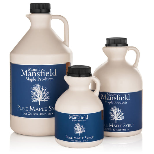 Pure Vermont maple syrup in a clear plastic jug by Mount Mansfield Maple Products, showcasing the syrup's golden color.