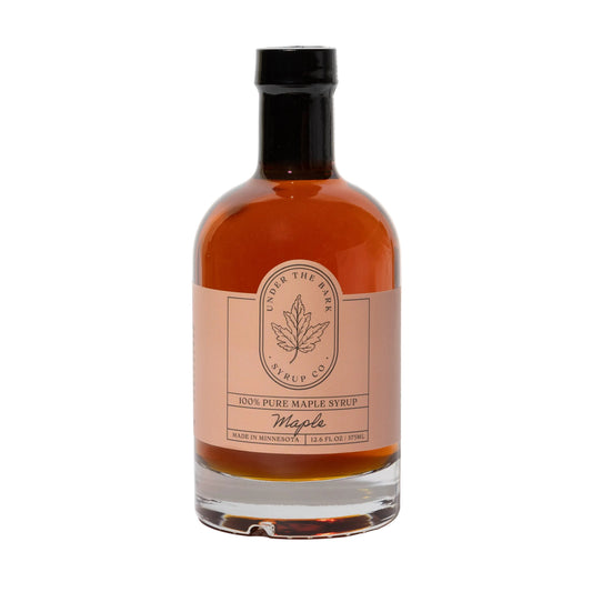 12oz bottle of Under The Bark Syrup Co maple syrup, rich golden color, glossy liquid, ideal for pancakes and breakfast.