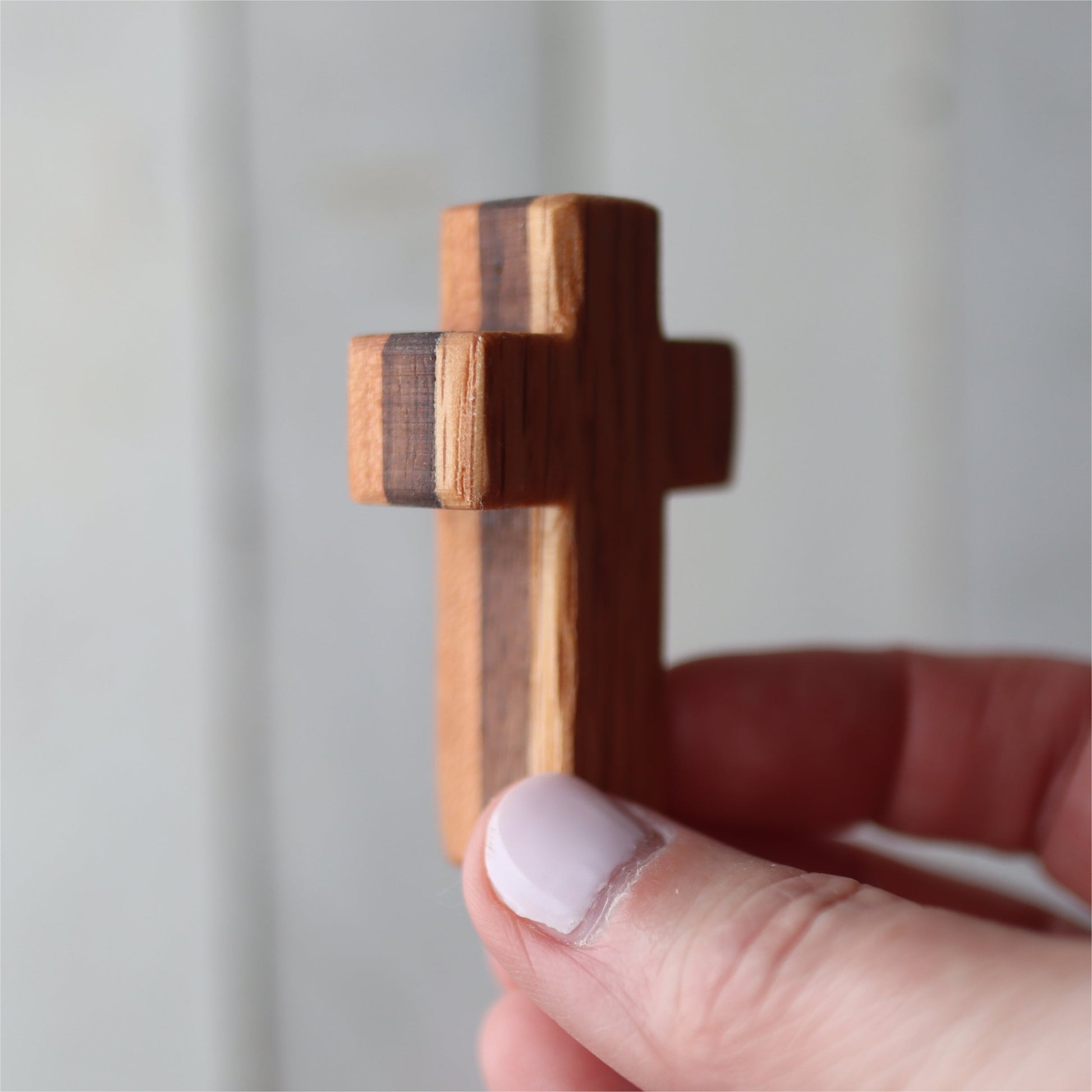 Handmade wooden pocket cross by Dennehey Design Co. featuring a detailed carved wooden cross suitable for personal or spiritual use