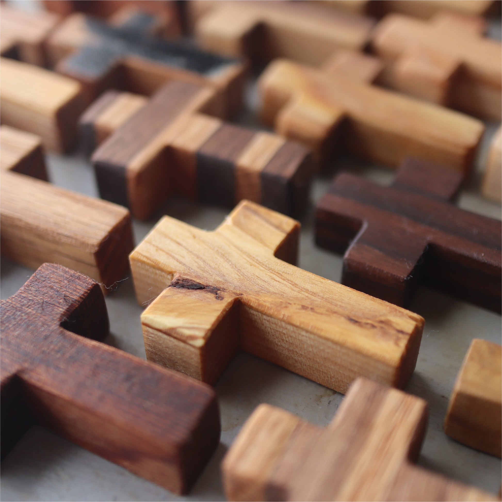 Handmade wooden pocket cross by Dennehey Design Co. featuring a detailed, natural wood finish and compact size.