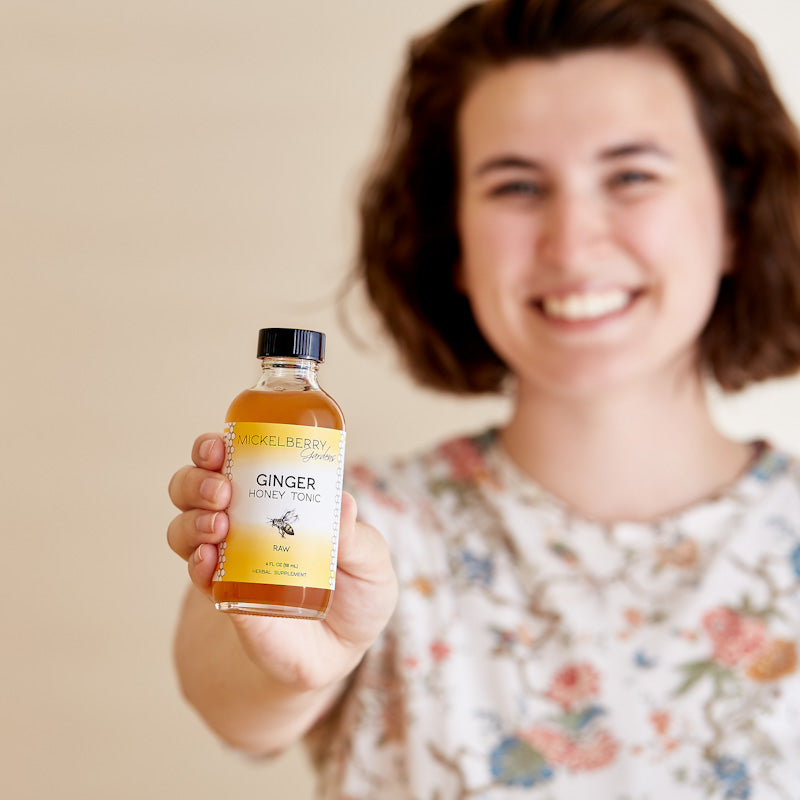 Mickelberry Gardens Ginger Honey Tonic in a 4oz bottle, held in hand, showing the product label and clear liquid inside.