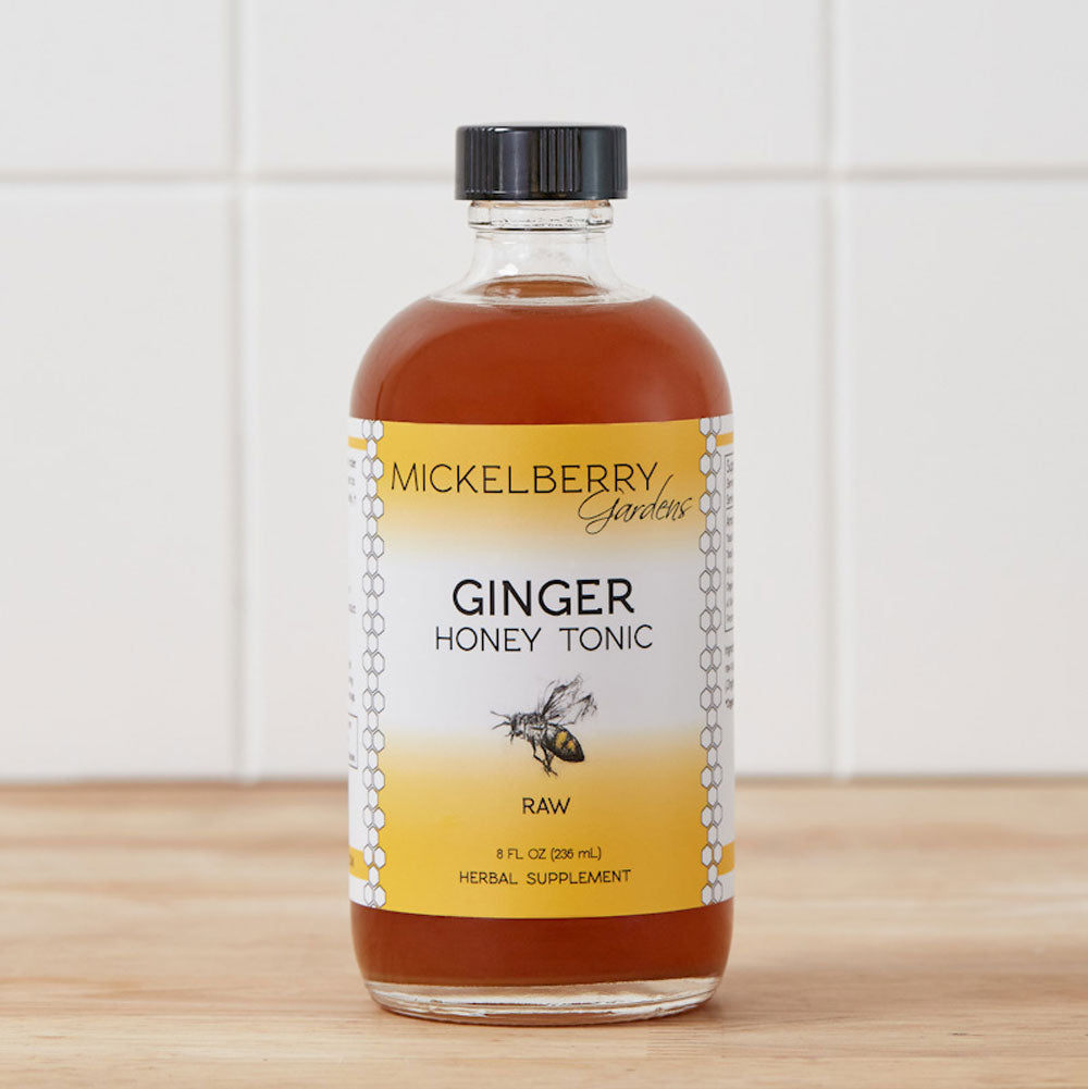8oz bottle of Mickelberry Gardens Ginger Honey Tonic with fresh ginger slices and honey in a clear glass bottle.