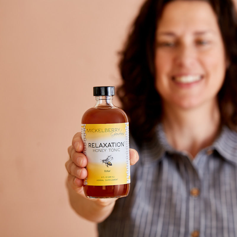 Mickelberry Gardens Relaxation Honey Tonic in an 8oz bottle, held by a person, showcasing natural honey tonic for calming wellness.