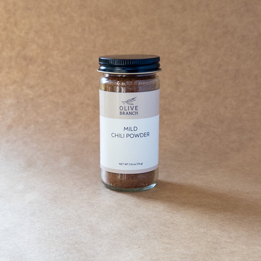 Olive Branch Oil & Spice mild chili powder blend in a glass jar, showing vibrant red chili flakes and spices.