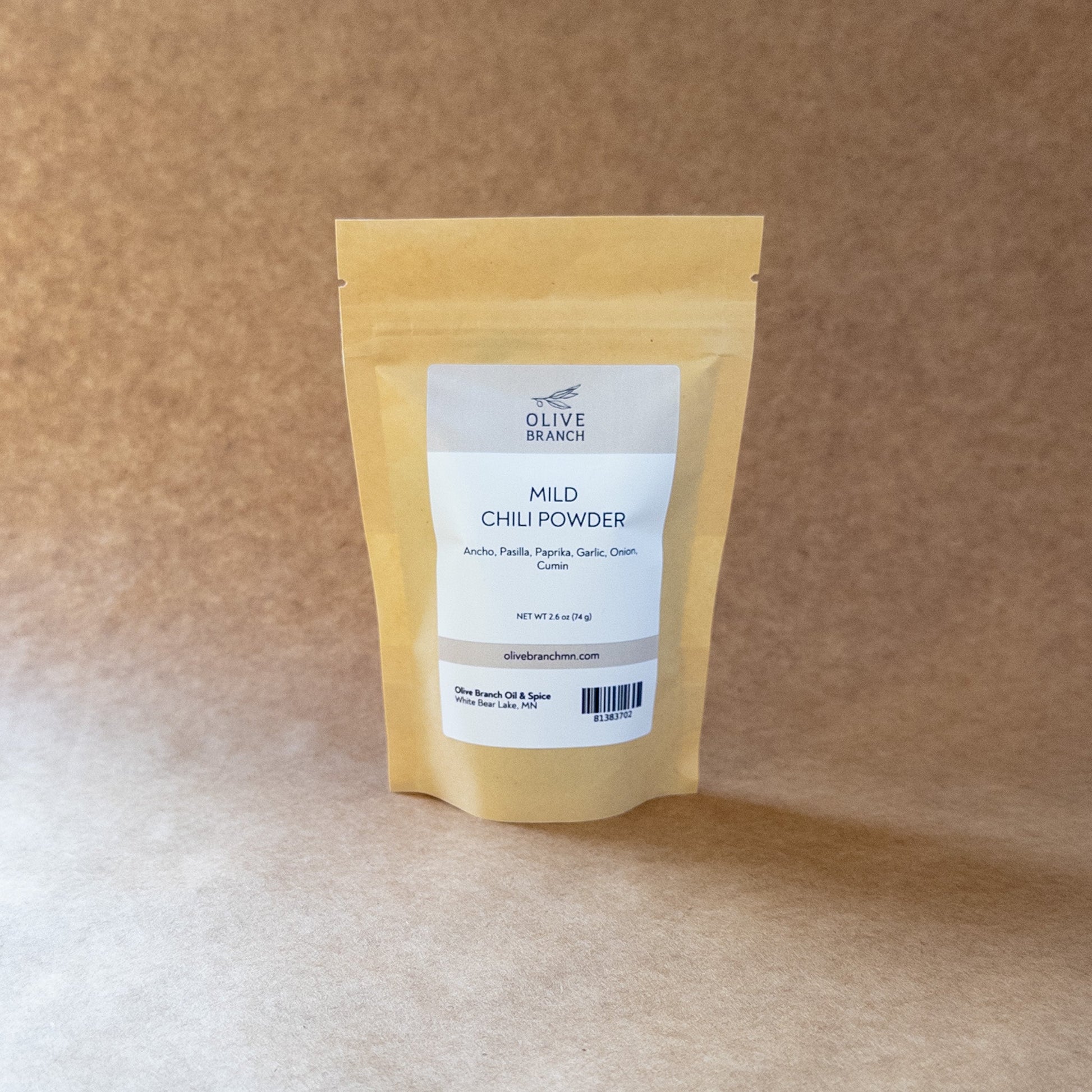 Olive Branch Oil & Spice mild chili powder blend in a clear glass jar, showing vibrant red chili powder inside.