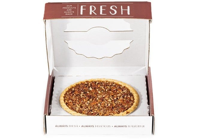 Slice of Millican Pecan Bourbon Pecan Pie with a golden crust and pecan topping, displayed on a white plate.