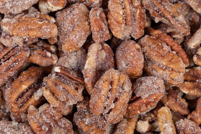 Millican Pecan cinnamon candied pecans in a 12oz bag, showing crunchy coated pecans with a cinnamon sugar glaze.
