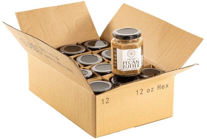 Eight jars of Millican Pecan Creamy Pecan Butter, 8.5oz each, displayed in a rustic country store setting.