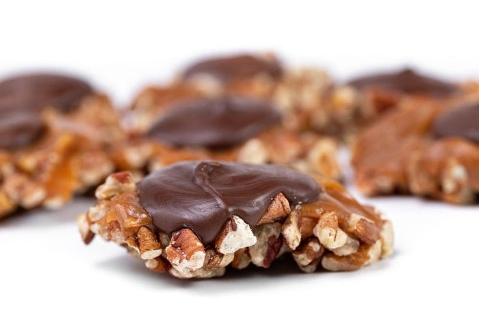 Dark chocolate Caramillicans pecan treats in a gift box by Millican Pecan, featuring rich chocolate and crunchy pecans.