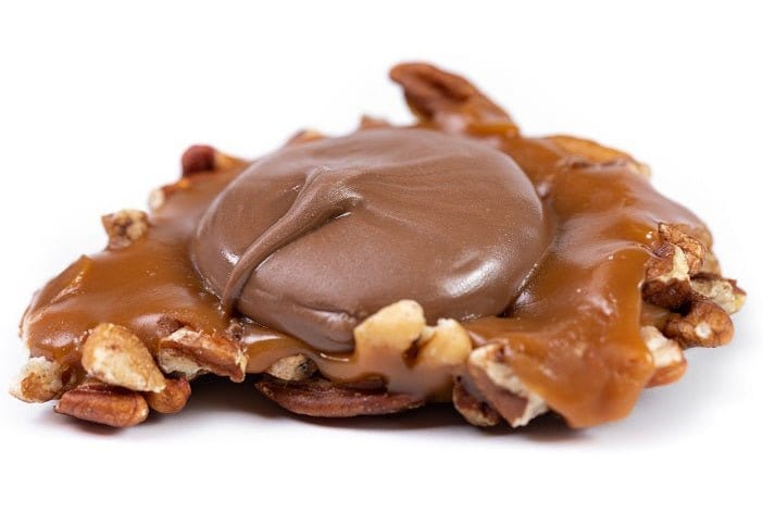 Milk chocolate Caramillicans pecan treats by Millican Pecan, showing individually wrapped pecan-filled chocolates with smooth milk chocolate coating.