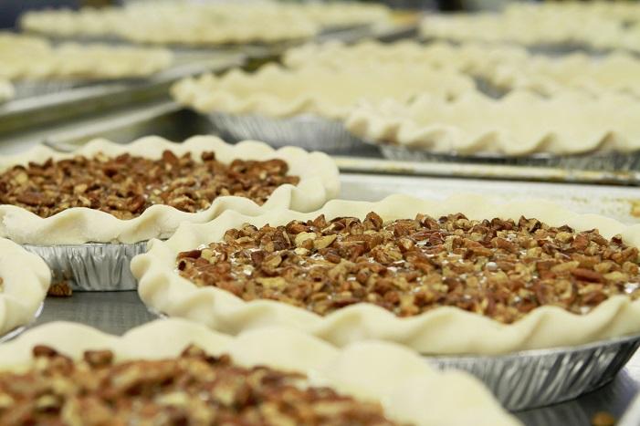 Slice of Millican Pecan Chocolate Pecan Pie with a rich chocolate layer and pecan topping on a plate.