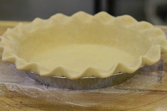 Millican Pecan Southern Pecan Pie in a pie crust, showcasing a golden, nut-filled dessert with pecans on top.