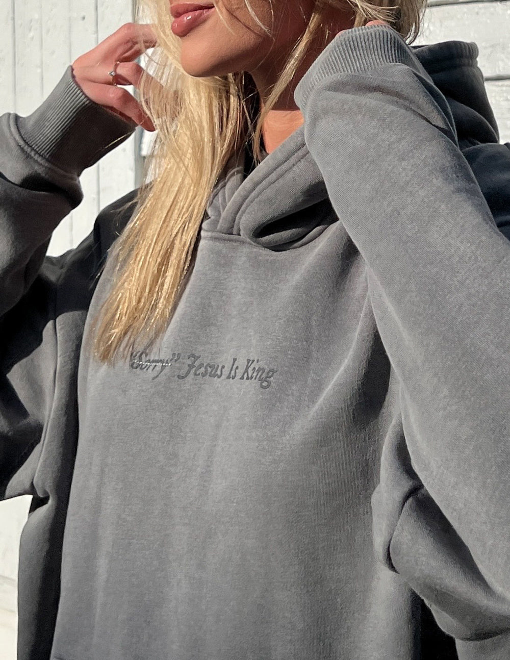 Unisex hoodie by Elevated Faith featuring "Not Sorry Jesus Is King" text, casual fit and soft fabric in the image.