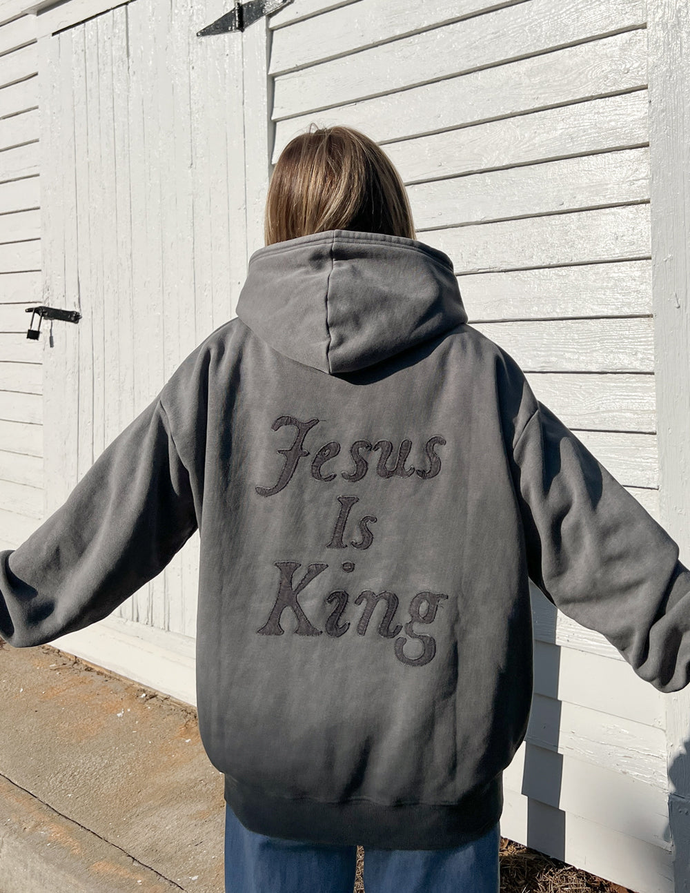 Unisex hoodie by Elevated Faith with "Not Sorry Jesus Is King" printed design in black and white on soft fabric.