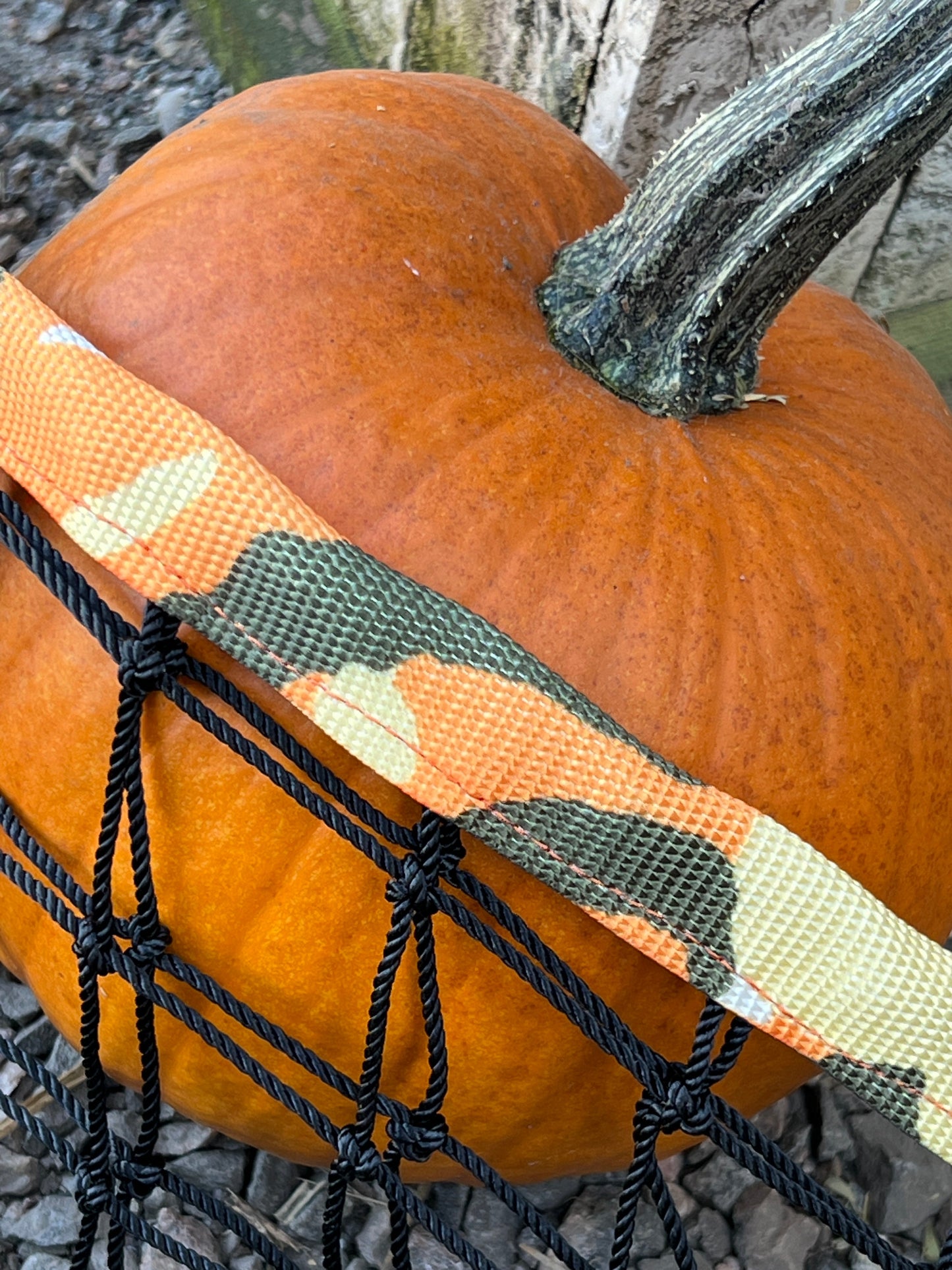 Orange camouflage haynet from Haylo Haynets, LLC, designed for feeding livestock with a durable, textured netting.