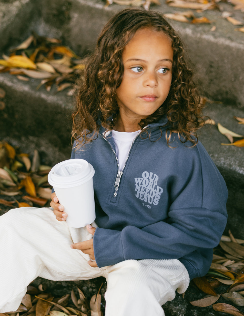 Kids jacket by Elevated Faith featuring "Our World Needs Jesus" slogan on a half-zip design, suitable for children.