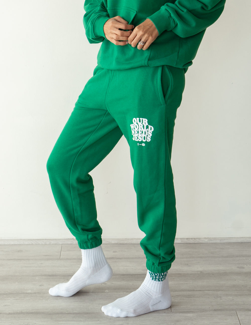 Unisex sweatpant by Elevated Faith with "Our World Needs Jesus" print, casual fit, soft fabric, in neutral color.
