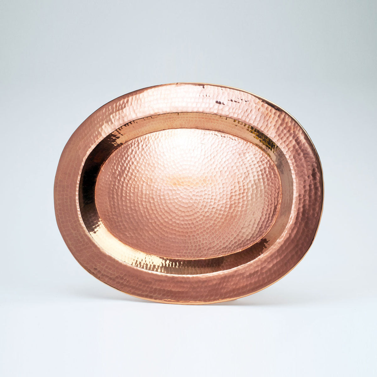 Medium Thessaly oval copper platter by Sertodo featuring a shiny, handcrafted copper surface perfect for serving.