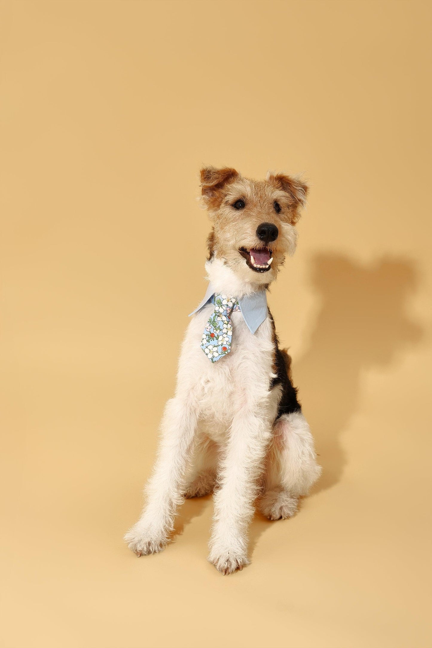Blue Botanique BarkBarkBaby necktie bandana featuring a vibrant botanical pattern on soft fabric, styled as a fashionable accessory.