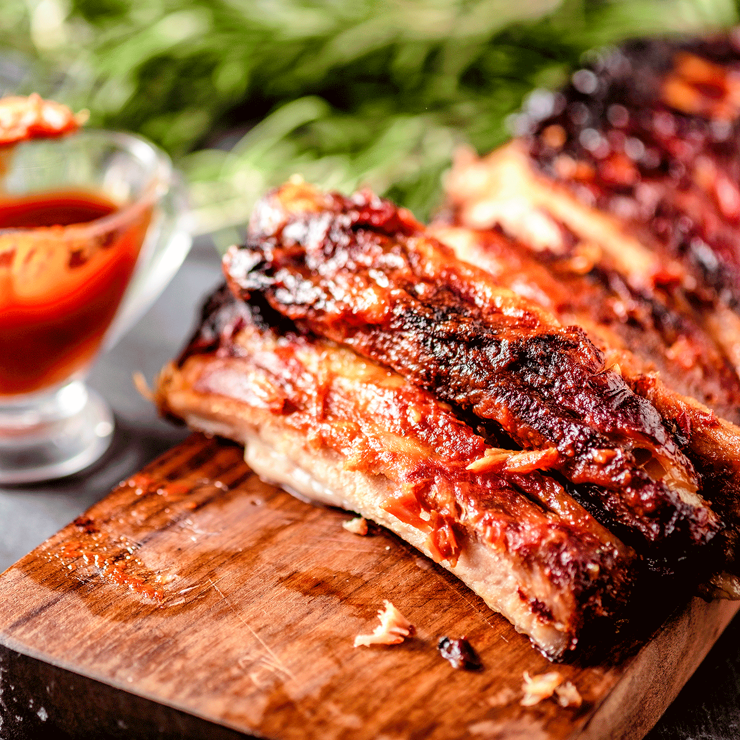 Pig of the Month BBQ Peach Sriracha Baby Back Ribs showcasing glazed, flavorful pork ribs with a spicy peach sriracha sauce.