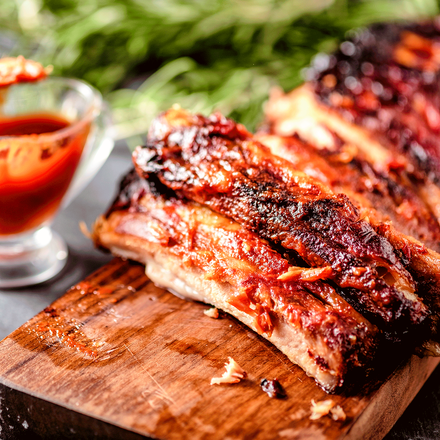 Pig of the Month BBQ Peach Sriracha Baby Back Ribs showcasing glazed, flavorful pork ribs with a spicy peach sriracha sauce.