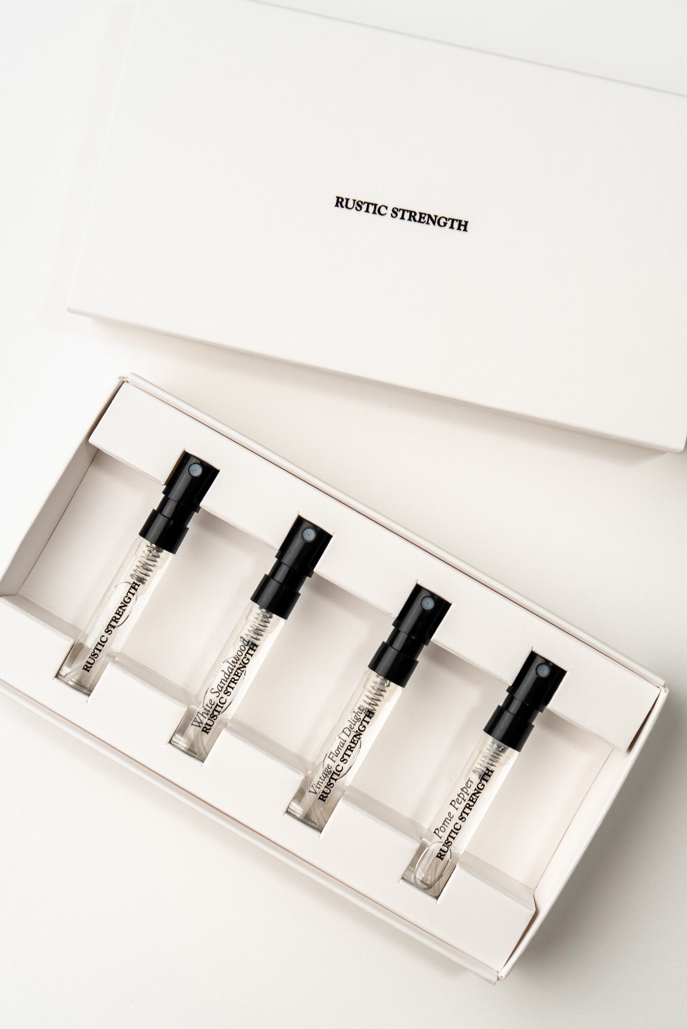 Rustic Strength perfume sample pack with four different scents displayed in small vials against a neutral background.