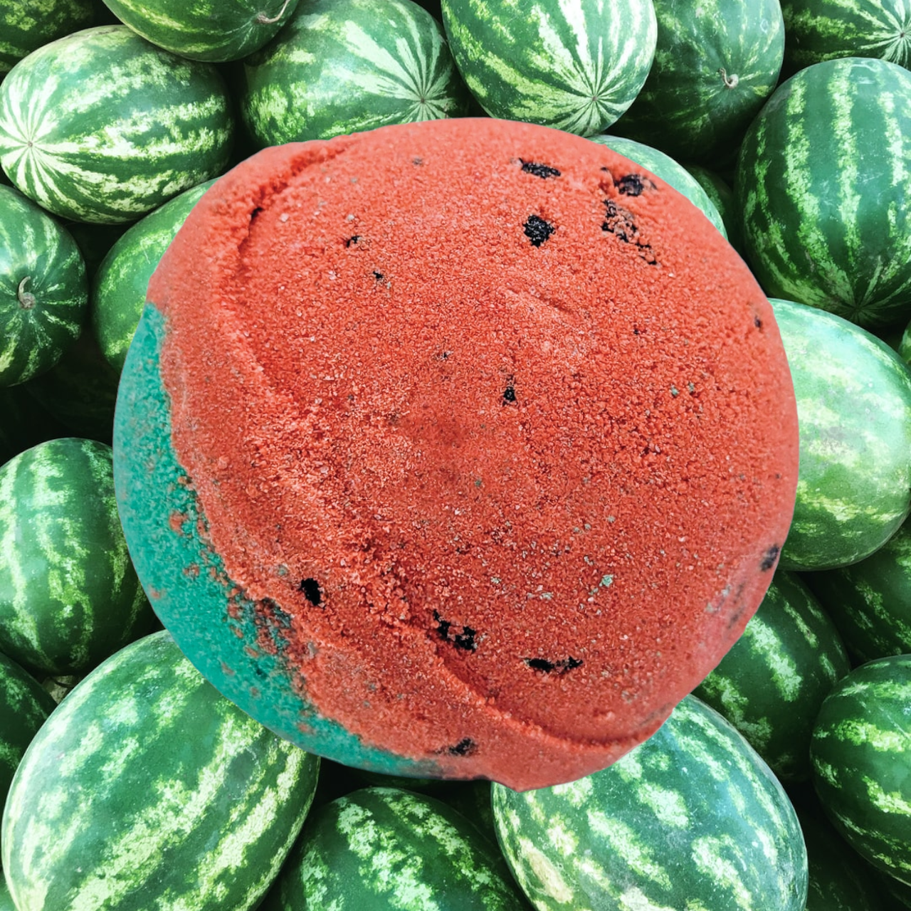 Evolve Botanica Watermelon Sugar bath bomb with pink and green swirls, round shape, and textured surface, ready for a relaxing bath.