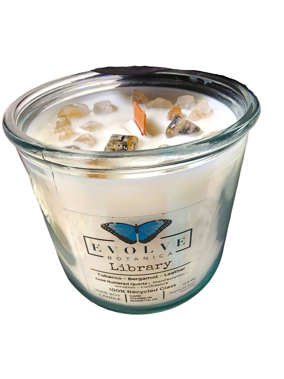Evolve Botanica Rocks Candle Library with wood wick, gold accents, rutilated quartz gemstone, soy wax, and decorative elements.