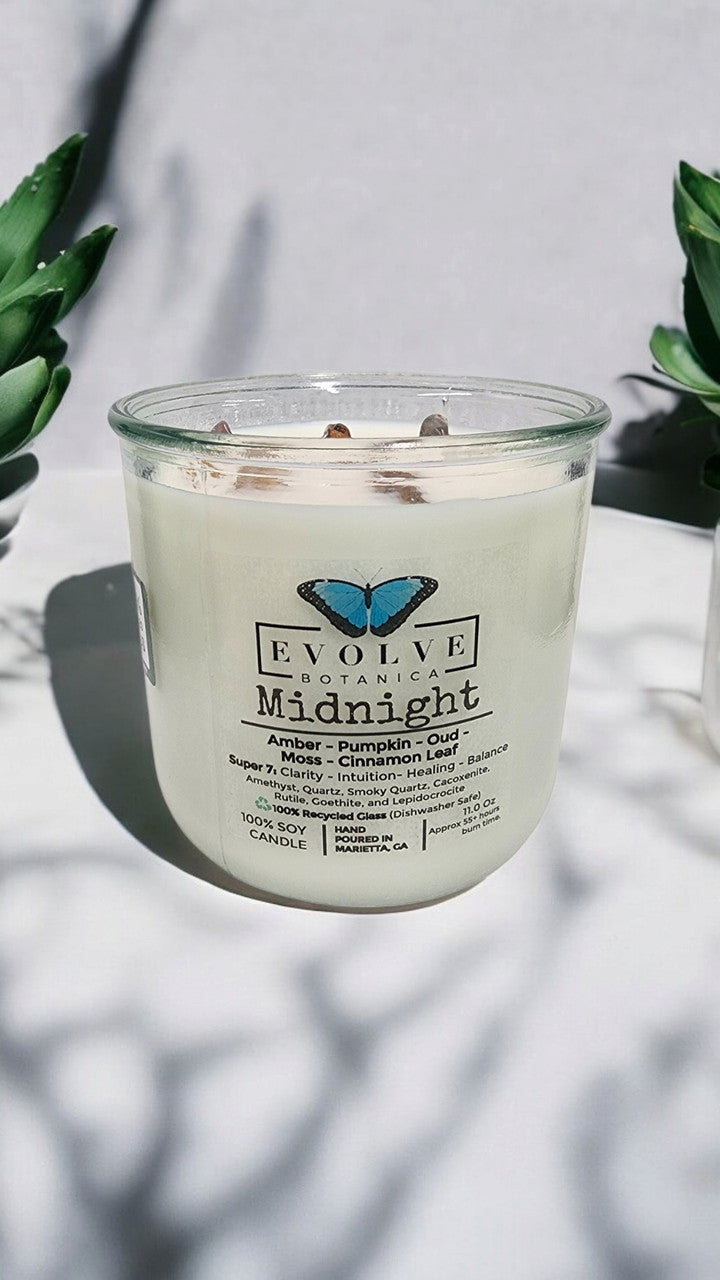 Midnight Rocks Candle by Evolve Botanica with wood wick and seven gemstone soy wax in a dark-colored container.