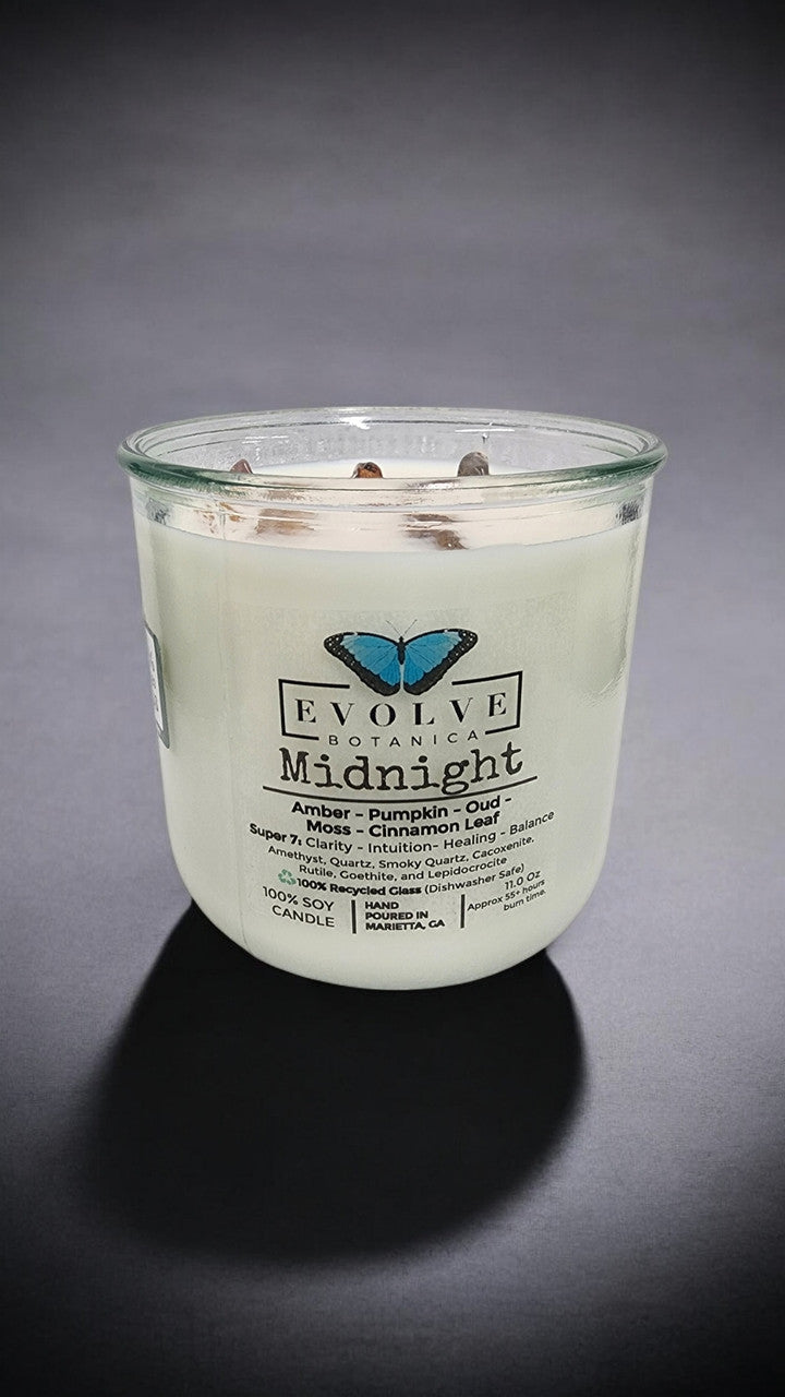 Evolve Botanica Midnight Rocks Candle with wood wick and super seven gemstone soy candle, showcasing a dark, elegant design.
