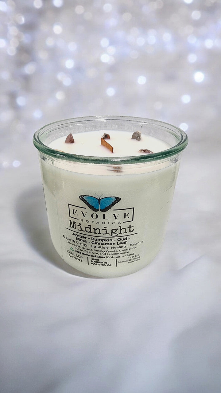 Evolve Botanica Midnight Rocks Candle with wood wick and seven gemstones in a glass jar, soy wax, and calming design.