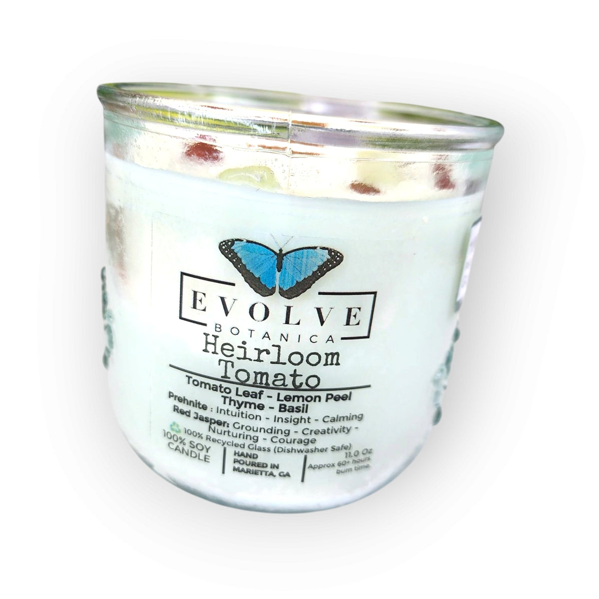 Evolve Botanica Rocks Candle Heirloom Tomato with wood wick, prehnite, and red jasper, soy wax in a clear glass jar.